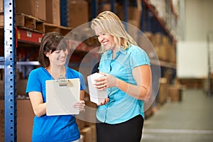 Businesswoman And Female Worker In Distribution Warehouse