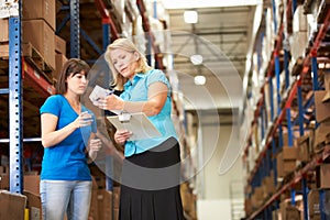 Businesswoman And Female Worker In Distribution Warehouse