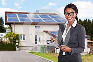 Businesswoman Filling Document In Front Of House photo