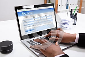 Businesswoman Filling Online Survey Form On Laptop