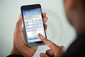 Businesswoman Filling Online Survey On Mobile Phone