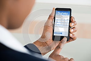 Businesswoman Filling Survey Form On Mobile Phone