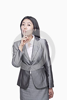 Businesswoman with finger on lips