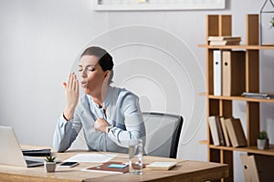 Businesswoman with fist on chest coughing