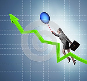 Businesswoman flying on hot balloon over graph