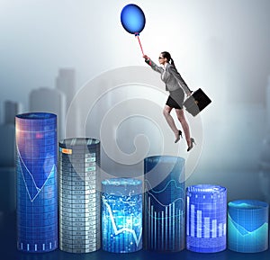 Businesswoman flying on hot balloon over graph