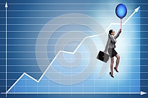 The businesswoman flying on hot balloon over graph