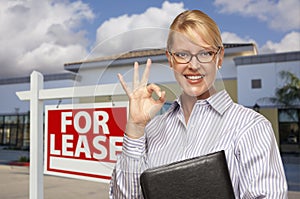 Businesswoman In Front of Office Building and For Lease Sign