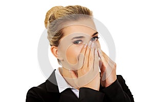 Businesswoman giggles covering her mouth with hand