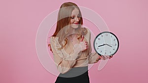 Businesswoman girl showing time on office clock, ok, thumb up, approve, pointing finger at camera