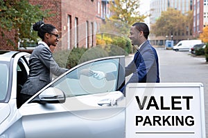 Businesswoman Giving Car Key To Male Valet