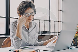 Businesswoman in glasses feeling tired, suffering from eye strain and fatigue during computer work