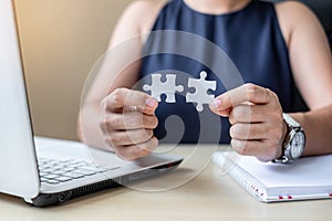 Businesswoman Hand connecting couple puzzle piece in office. Business solutions, mission, successful, goals and strategy concepts