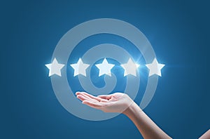 Businesswoman hand holding five stars isolated