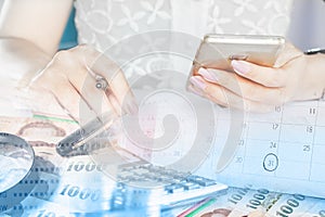 Businesswoman hand holding smart phone, money and calenda