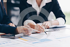Businesswoman hand pen pointing on business document at meeting discussion and analysis data the charts and graphs.