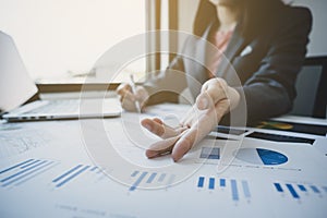 Businesswoman hand pointing and analysis the graph with calculator and laptop at the home office for setting challenging business