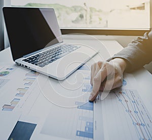 Businesswoman hand pointing and analysis the graph with laptop at the home office for setting challenging business goals And