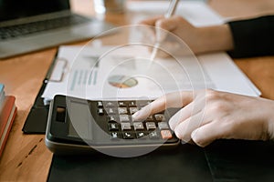 Businesswoman hand pressing on calculator for calculating cost estimating