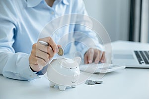 Businesswoman hand putting coin into piggy bank, step up start up business to success, Saving money for future plan and retirement