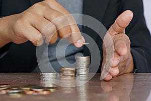 Business woman hand putting money coin stack. Creative ideas for saving money concept
