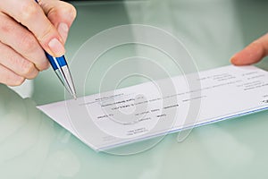 Businesswoman Hand Signing Cheque