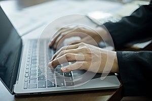 The businesswoman hand sits at their desks and calculates financial graphs showing the results of their investments planning the