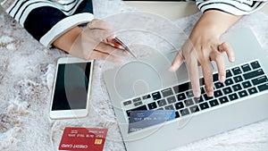 Businesswoman hand use laptop and holding credit card to online shopping from home, payment e-commerce, internet banking, spending