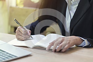 Businesswoman hand writing checklist on notebook, planning concept