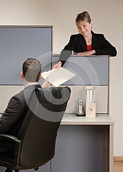 Businesswoman handing co-worker file folder