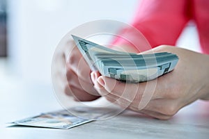 Businesswoman hands counting usa dollars on table in office