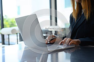 Businesswoman hands entering the PIN code on her laptop. Cyber security concept