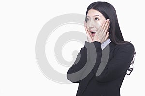 Businesswoman with hands on face acting surprised, studio shot