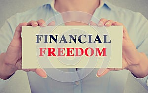 Businesswoman hands holding card sign with Financial freedom message