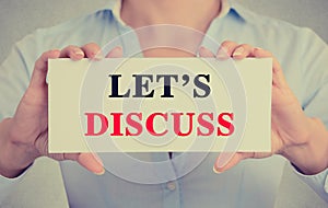 Businesswoman hands holding card sign with let's discuss message