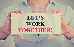 Businesswoman hands holding card sign with let's work together