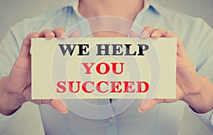 Businesswoman hands holding sign we help you succeed photo