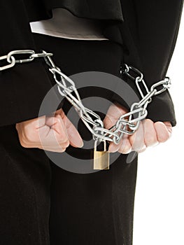 Businesswoman with hands shackled in chains.