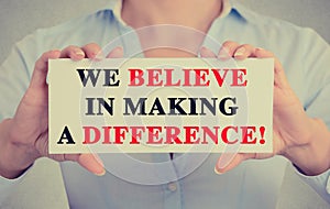 Businesswoman hands sign with We Believe in Making a Difference message