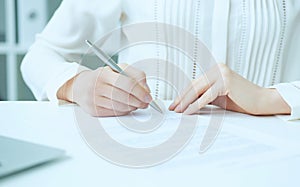 Businesswoman hands sign contract on desk. Female entrepreneur puts signature on official agreement. Profitable deal