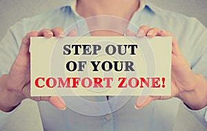 Businesswoman hands sign with step out of your comfort zone message