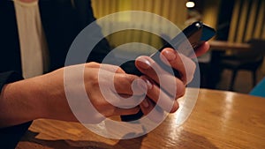 Businesswoman hands texting, sending sms on smartphone and drinking coffee in cafe. 4k, slow motion.