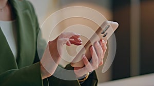 Businesswoman hands using smartphone in office closeup. Woman watching pictures