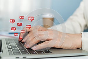 Businesswoman hands working on digital laptop computer with social network icon on desk