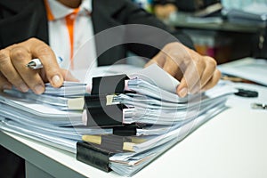 Businesswoman hands working on Stacks of documents files for fin