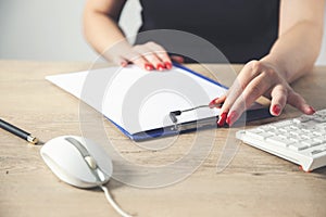 Businesswoman hands working in stacks of paperwork files for searching information on work desk office, business report papers