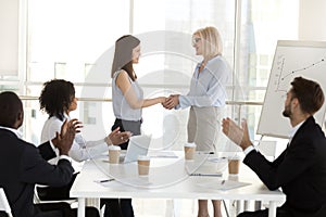 Businesswoman handshake female employee congratulating with succ photo