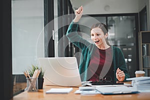 Businesswoman happy and cheerful for successful on project via laptop