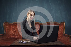 Businesswoman, happy woman in suit smiling using laptop for work in vintage interior