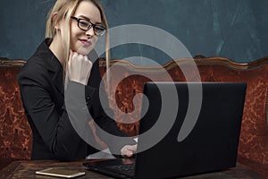 Businesswoman, happy woman in suit smiling using laptop for work in vintage interior